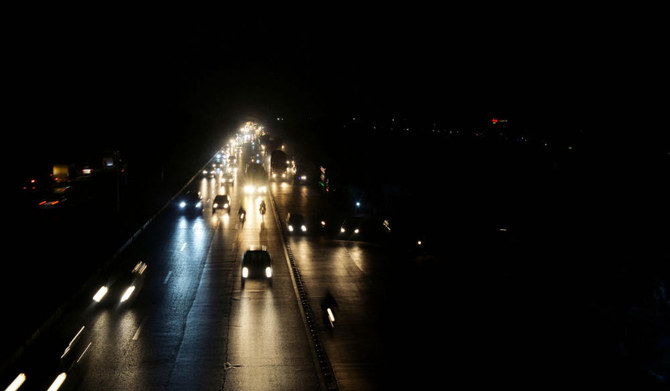 Commuters make their way along a street during a nationwide power outage, in Islamabad on January 23, 2023. (AFP)
