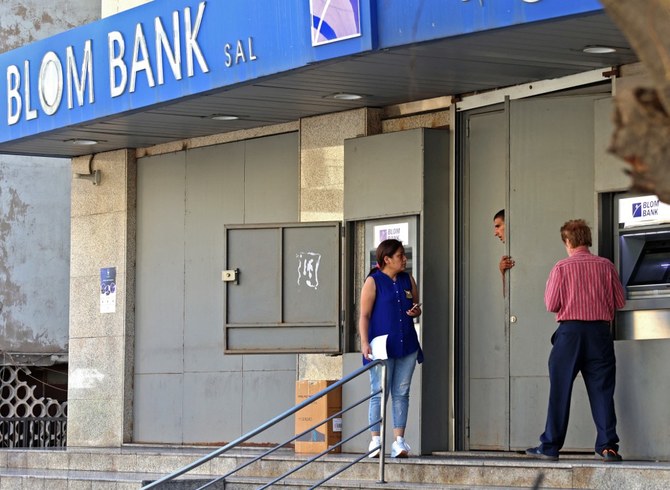 Lebanese depositors withdraw money from an ATM machine outside BLOM bank in Beirut. (File/AFP)