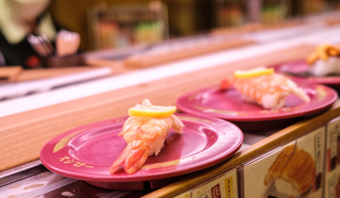 This picture shows plates of sushi on a conveyor belt at a sushi chain restaurant in Tokyo on February 3, 2023. (AFP)