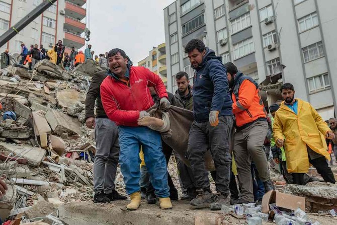 Rescuers carry a body found in the rubble in Adana on February 6, 2023, after a 7.8-magnitude earthquake struck the country