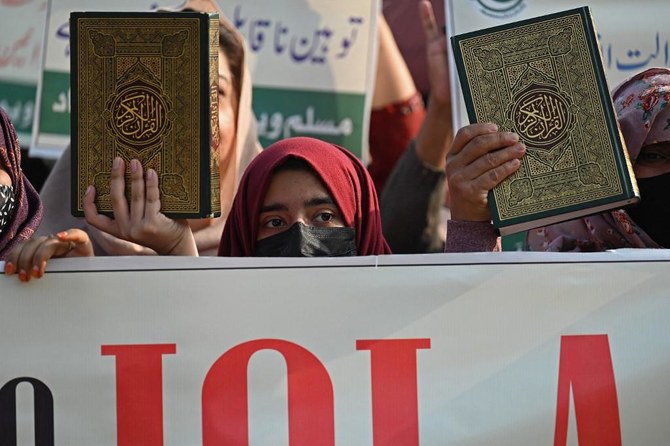 People hold copies of the holy Qur’an while taking part in a protest in Islamabad, Pakistan. (File/AFP)