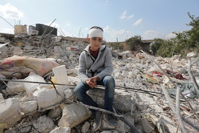A Syrian boy sits amid the rubble of his family home in the town of Jindayris, Aleppo. (File/AFP)