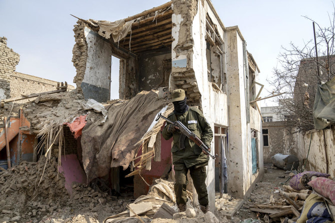 A Taliban fighter checks a Daesh house that was destroyed in the ongoing conflict between the two in Kabul, Afghanistan. (AP)