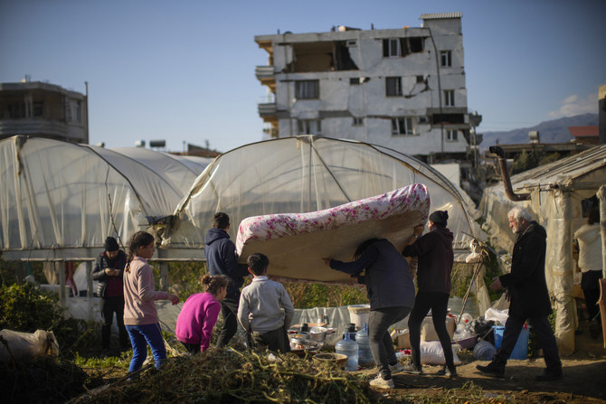 Local residents bring a mattress to a greenhouse where they shelter after the earthquake in Samandag, Turkiye. (AP)