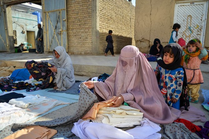 Afghan burqa-clad women sell clothes along a street in Kandahar on March 7, 2023. (File/AFP)
