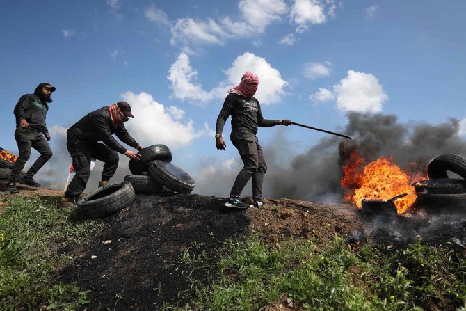 Palestinian protesters burn tyres during a small protest called for by Hamas east of Gaza City by the border with Israel.