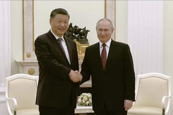 China's President Xi Jinping, left, and Russian President Vladimir Putin shake hands during their meeting in Moscow.