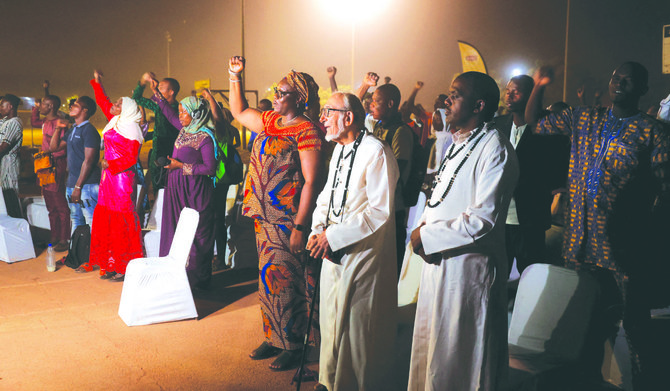 Burkinabe Muslims and Christians chant the national anthem while they gather to break the fast together. (Reuters)