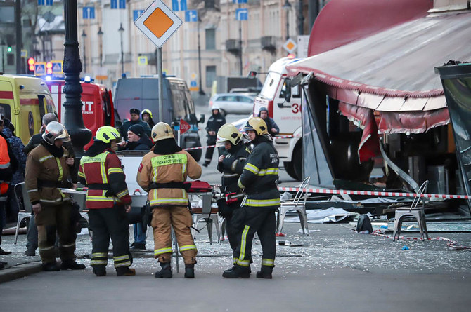 Russian Emergency Situations Ministry stand at the side of an explosion at a cafe in St. Petersburg, Russia, Sunday.