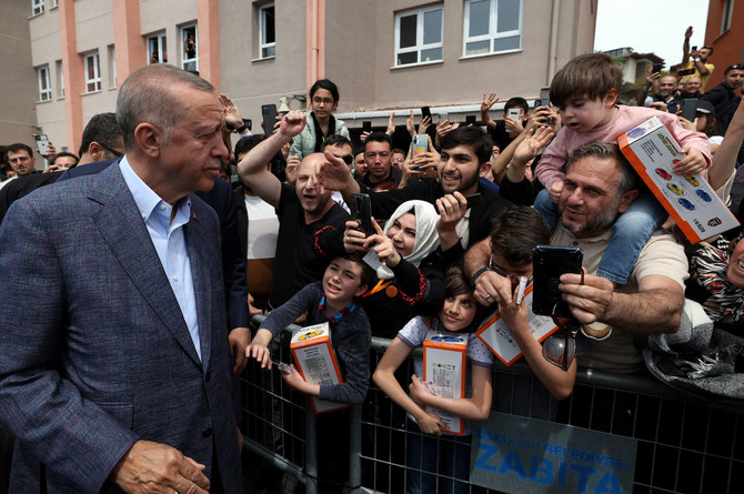 Turkish President Tayyip Erdogan greets his supporters after he casts his ballot at a polling station in Istanbul, Turkey.