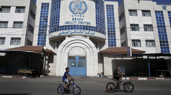 Children ride their bicycles in front of a health center run by the United Nations Relief and Works Agency in Gaza