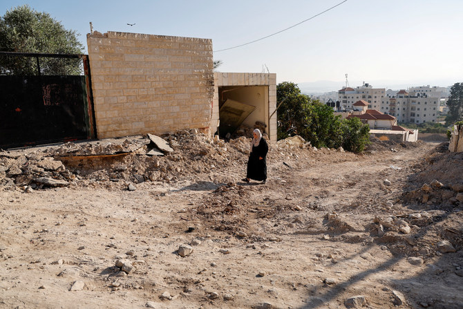 A Palestinian woman walks near her destroyed home, after a two-day Israeli raid in Jenin in the Israeli-occupied West Bank.
