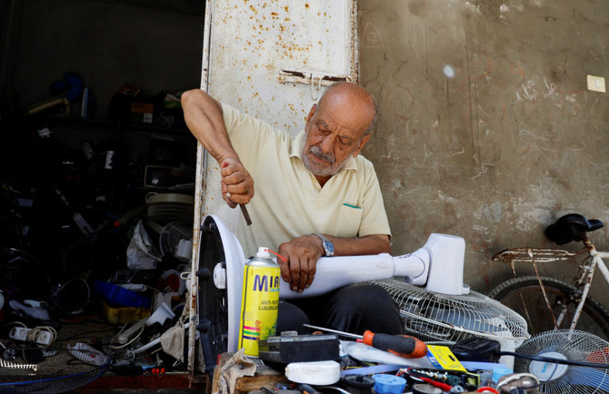 A Palestinian, Mustafa Abdou, repairs a fan in his shop amid a heatwave at the Shati refugee camp in Gaza City, July 25, 2023. 