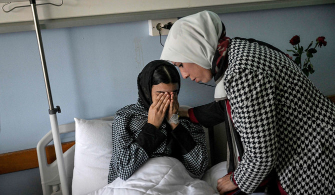 Dr. Fadwa El-Fartass in Benghazi, Libya, attends to Ibrar Goma, a 15-year-old survivor of the Derna flooding. (AFP)