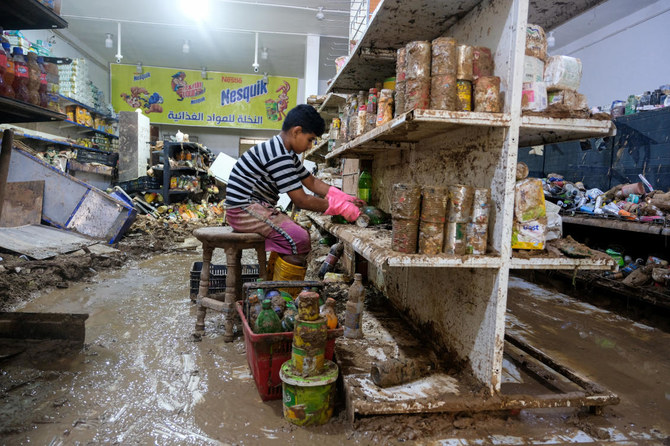 A boy cleans merchandise inside a damaged grocery store affected by fatal floods, in Derna, Libya, September 28, 2023. (Reuters)