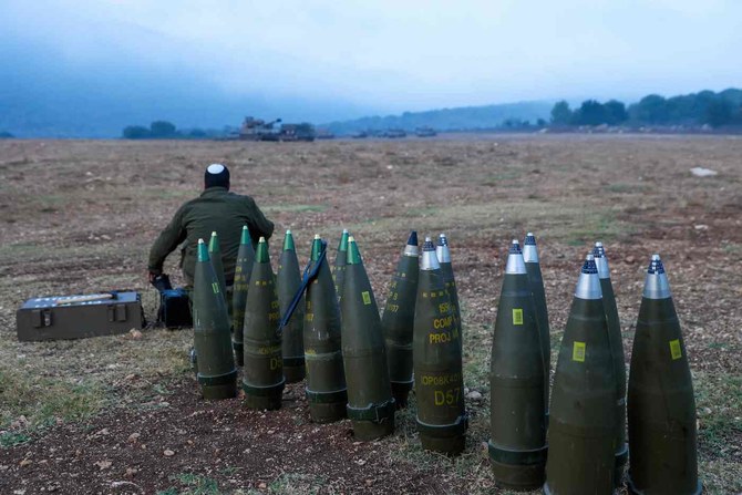 An Israeli soldier rests next to artillery shells in northern Israel on October 8, 2023. (AFP)