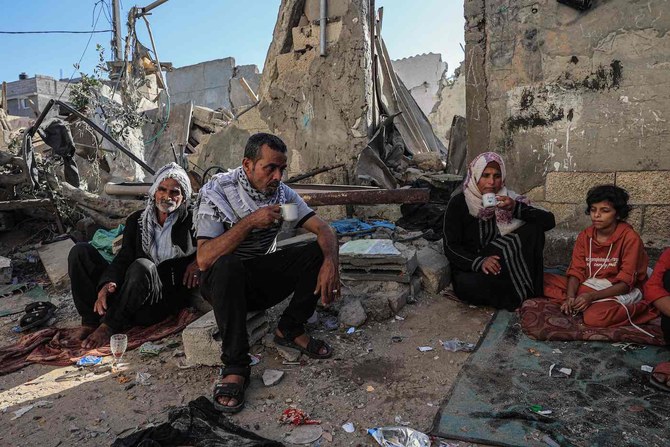 A family drink tea amid the rubble of a building destroyed in Israeli bombing in Rafah in the southern Gaza Strip, on November 7