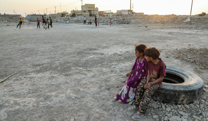 Iraqi children sit in an empoverished area on the edges of Nasiriyah, capital of Dhi Qar province, on September 25, 2023. (AFP)