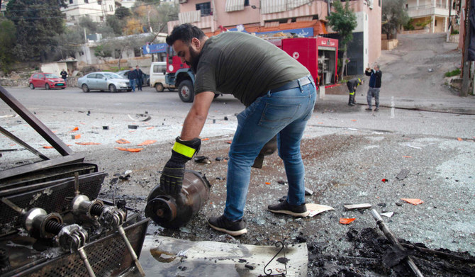 Emergency service members work at the site of Israeli shelling which hit a supermarket and a coffee shop in Adaysseh, Lebanon. 