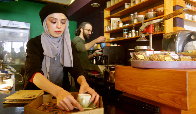 Cafe owner Ihsan al-Azmeh (R) prepares coffee in the Syrian capital Damascus on January 30, 2023. (AFP)