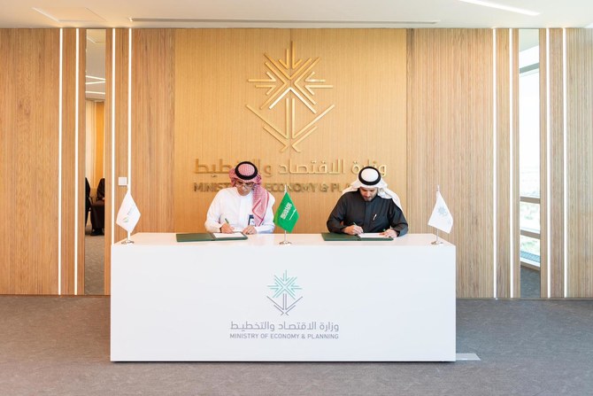 Representatives of Saudi Arabia’s Ministry of Economy and Planning and the Saudi National Institute of Health sign a MoU.