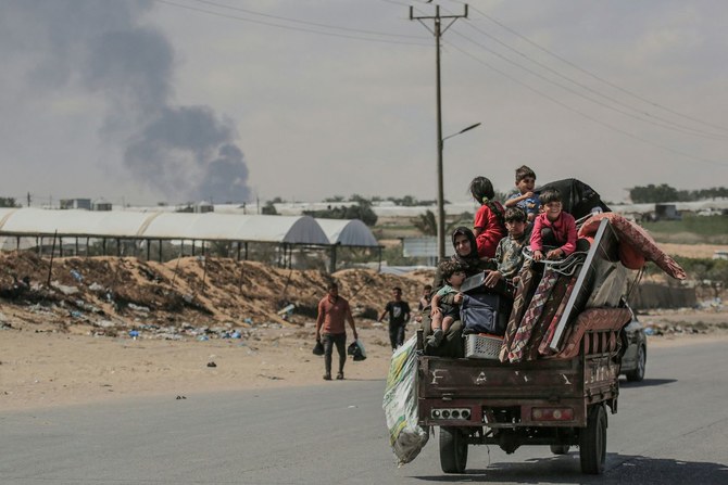 Palestinians fleeing with their belongings ride atop their vehicle in Rafah in the southern Gaza Strip on May 29, 2024. (AFP)