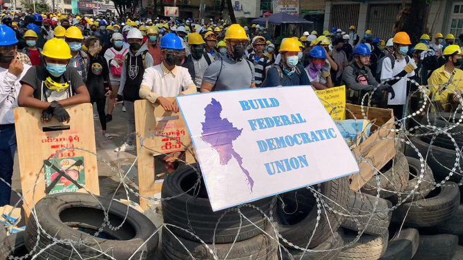 Protesters wearing helmets stand behind a barricade in Sanchaung, Yangon, Myanmar March 3, 2021, in this still image from a video obtained by Reuters. (Reuters)