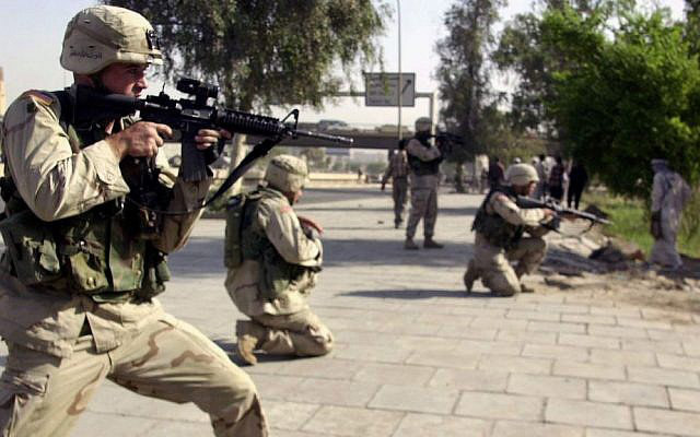 In this Oct. 4, 2003 file photo, American soldiers aim towards a stone-throwing mob of ex-Iraqi soldiers in central Baghdad, Iraq. (AP file photo)
