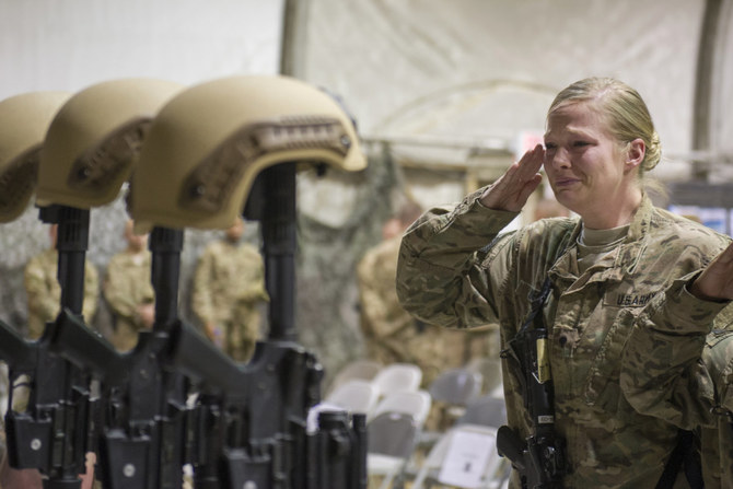 In this Dec. 23, 2015 file photo, a US soldier salutes her fallen comrades during a memorial ceremony for six Airmen killed in a suicide attack, at Bagram Air Field, Afghanistan. (US Air Force photo via AP)