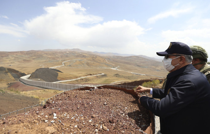 Turkey's Defense Minister Hulusi Akar check a security wall at the Turkey-Iran border in Van, eastern Turkey, on Aug. 15, 2021. Turkey says it will work for stability in Afghanistan to stem a growing migration wave. (AP/Pool)