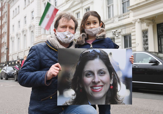 عرضت نسان زكاري رادكليف صورة لزوجها وابنتها الصغيرة احتجاجا على احتجاز نظام الرسوم الكاريكاتورية الإيراني كرهائن.  (تويتر)