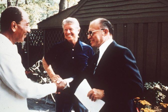 Egyptian President Anwar Sadat shakes hands with Israeli PM Menachem Begin at Camp David, Maryland, Sept. 1978. (AP Photo)