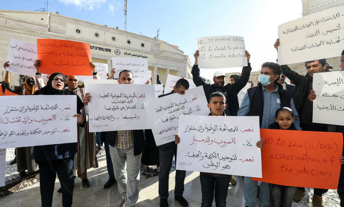 Libyan NGO activists gather for a demonstration in Tripoli on Dec. 15, 2021, to protest against any possible postponement of the upcoming elections scheduled for Dec. 24. (Photo by Mahmud Turkia / AFP) 