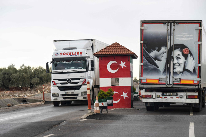 Turkish lorries drive through a checkpoint manned by the Turkish-backed Free Syrian Army in Afrin, northern Syria, on Dec. 8, 2021. (Photo by Rami Al Sayed / AFP)