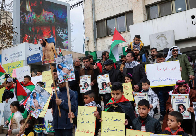 I sostenitori del prigioniero palestinese in sciopero della fame Hisham Abu Hawash si sono radunati a Hebron, nella Cisgiordania occupata, il 2 gennaio 2022, per chiedere il suo rilascio dalla detenzione israeliana senza accuse.  (Foto di Hazem Bader / AFP)