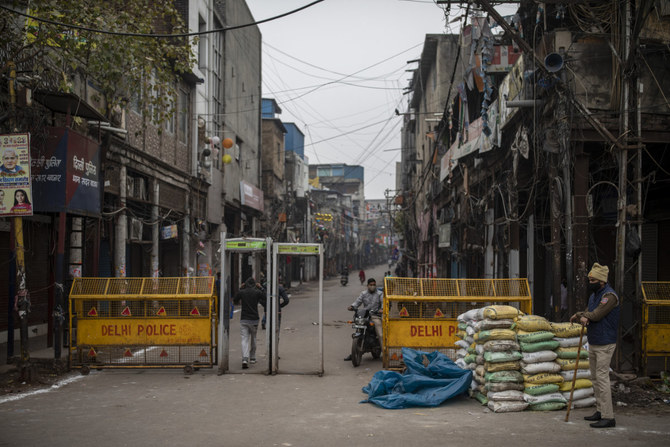A policeman stands guard at the deserted wholesale Sadar Bazar market in New Delhi on Jan. 15, 2022 to fight the COVID-19 pandemic, which has dragged down India's industrial output. (AP Photo/Altaf Qadri)
