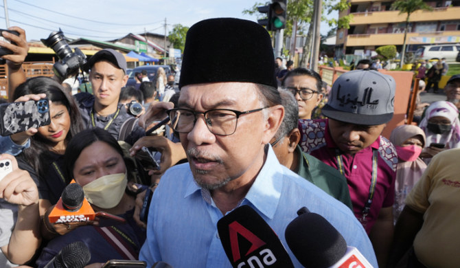 Malaysian opposition leader Anwar Ibrahim is mobbed by the media after casting his vote in Malaysia, Nov. 19, 2022. (AP)