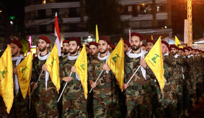 Fighters with the Lebanese Shiite Hezbollah party, carrying flags as they parade in Beirut. (AFP)
